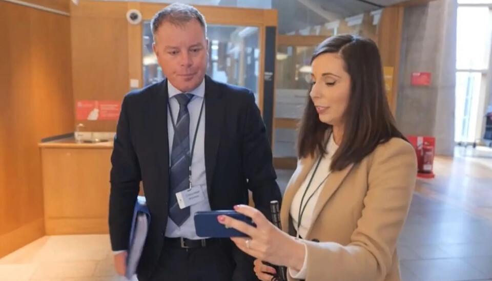 El director de operaciones de Mowi Escocia, Ben Hadfield, observa imágenes de peces enterrados en el sitio de Whiteshore Cockles, mostradas por la periodista de ITV Louise Scott.